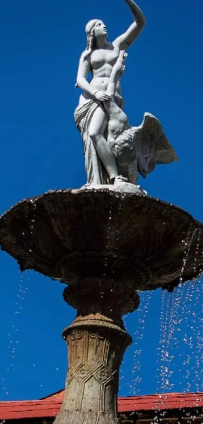 Elegant stone fountain against a clear blue sky with water droplets cascading.