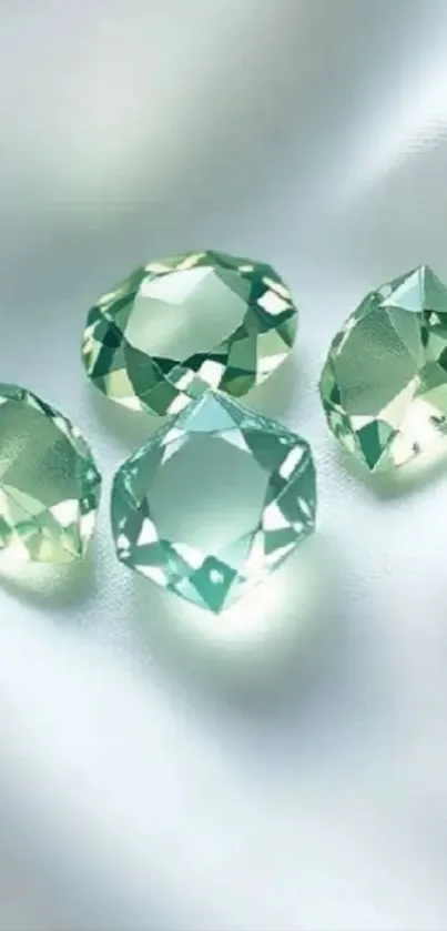 Four shimmering gemstones on soft fabric background.