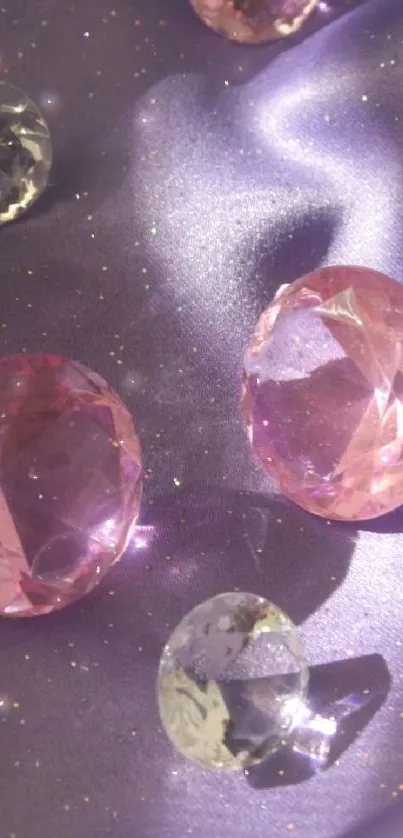 Glistening pink gemstones on purple silk background.