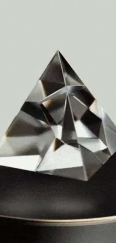 A geometric crystal pyramid on a gray background.