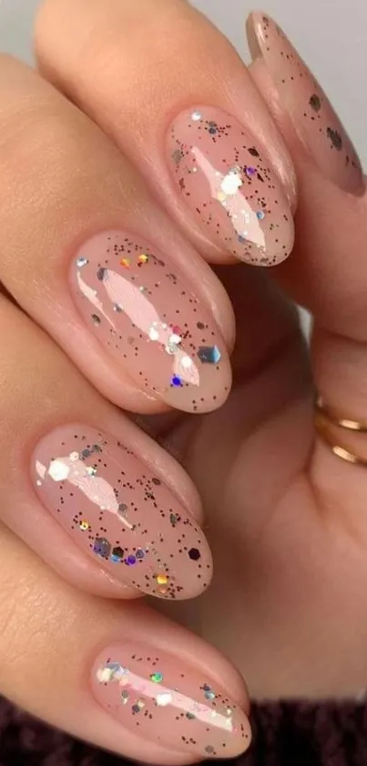 Close-up of glittery pink manicure on nails.