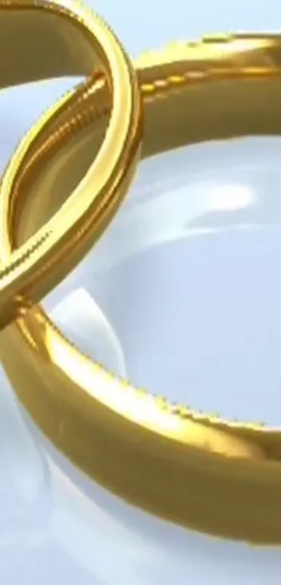 Intertwined gold rings on sleek surface.