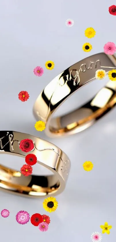 Two gold rings with elegant engravings on a reflective surface.