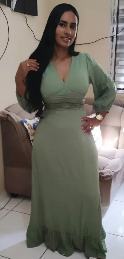 Woman in elegant green dress standing in stylish room.