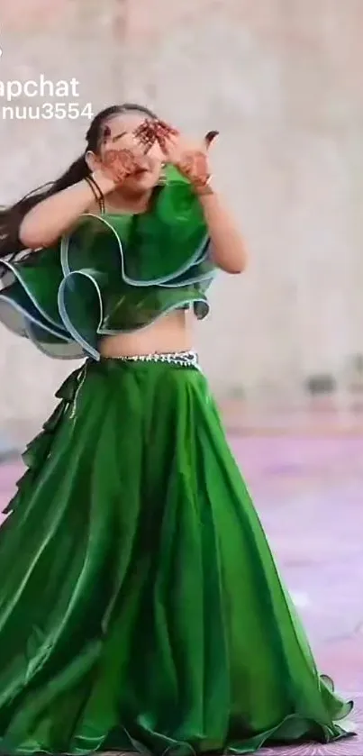 Woman in flowing green dress dancing gracefully in elegant attire.