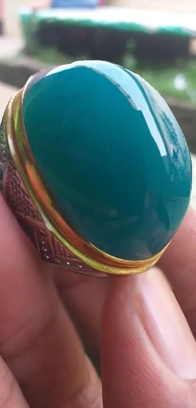 Close-up of a gorgeous green gemstone ring, held delicately.