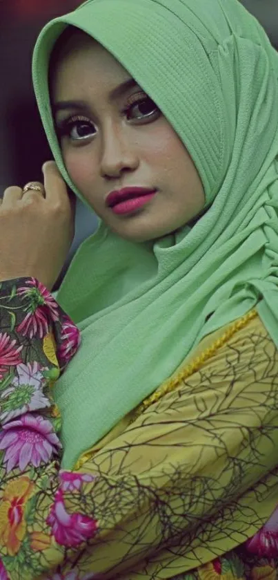 Elegant woman in green hijab with floral attire.