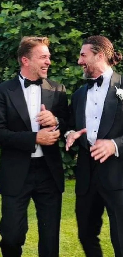 Groomsmen in tuxedos laughing outside.