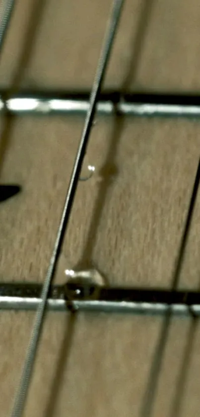 Close-up of guitar strings with a beige wood background for mobile wallpaper.