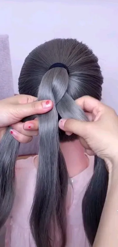 Hands elegantly braiding long grey hair in detailed style.