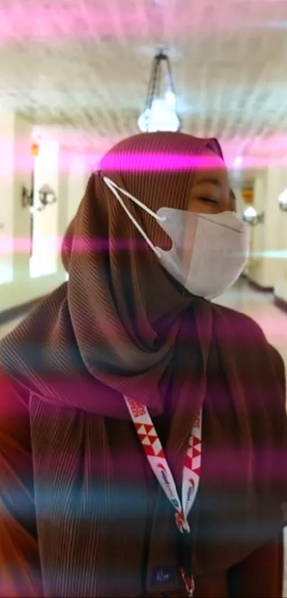 Woman in brown hijab in an elegant, well-lit hallway.