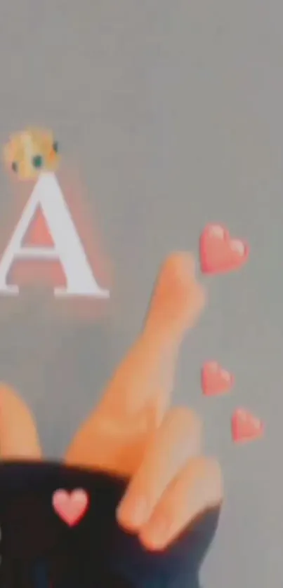 Hand with red hearts and crowned 'A' on gray background.