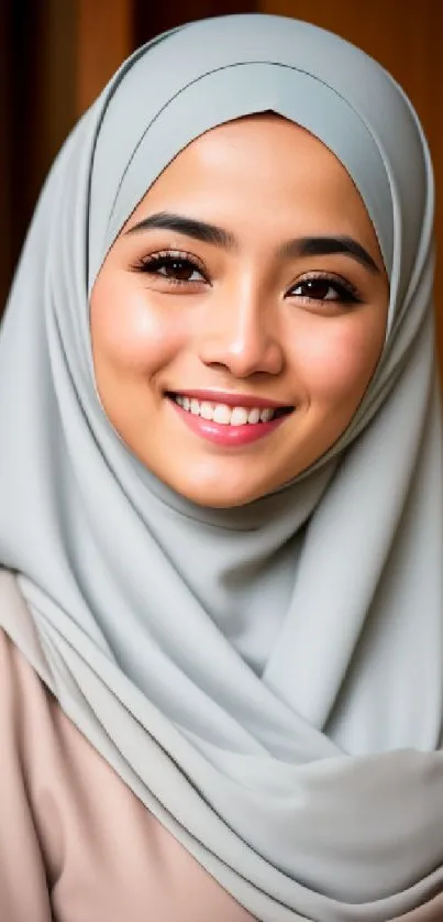 Elegant woman in light grey hijab, smiling gracefully.