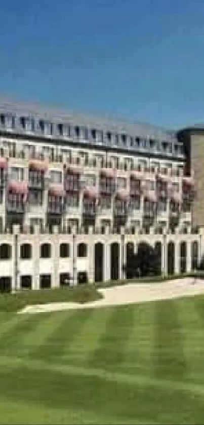 Elegant hotel with golf course under clear blue sky.