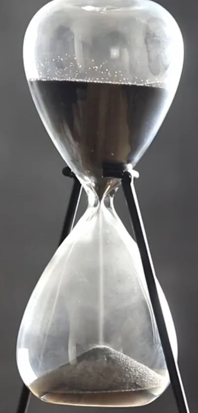 Elegant hourglass with sand in black and white tones, symbolizing time's flow.