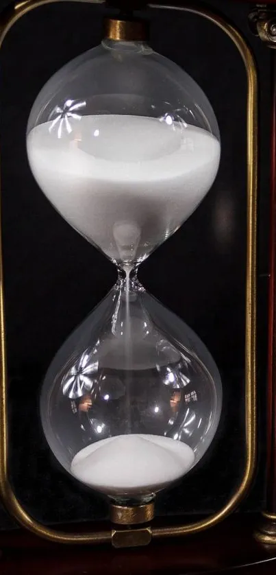 Elegant hourglass in mahogany frame with glass sand timer.