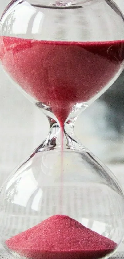 Elegant hourglass with pink sand pouring gracefully.