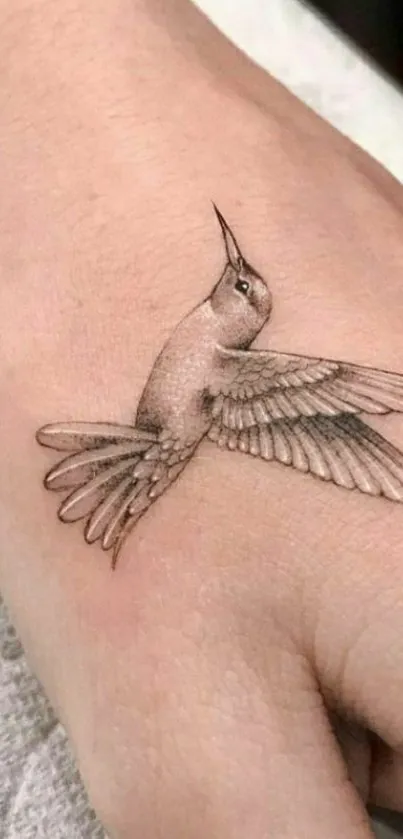 Minimalist hummingbird tattoo on hand, showcasing delicate artistry.