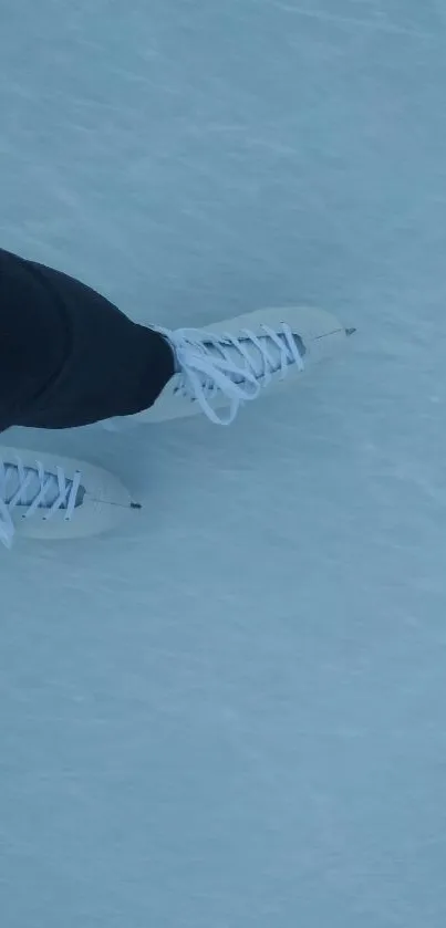 Close-up of white ice skates gliding on icy surface.