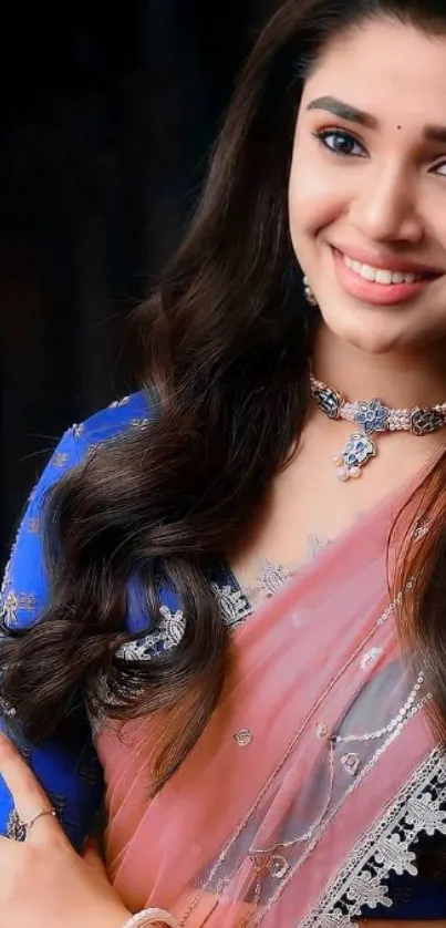 Woman in Indian attire with jewelry, smiling.