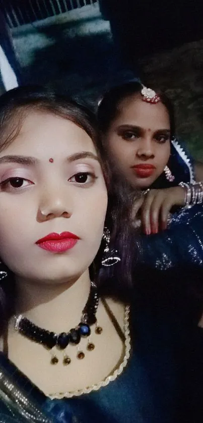 Elegant portrait of two women in traditional Indian attire and jewelry.