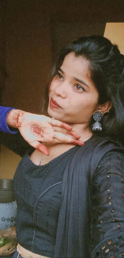 Portrait of a woman showcasing traditional Indian fashion with henna art.