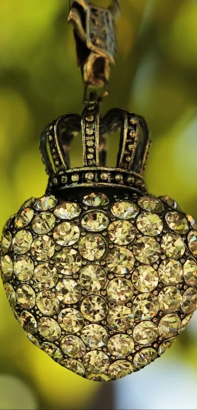 Luxurious heart pendant with jewels and crown on green bokeh background.