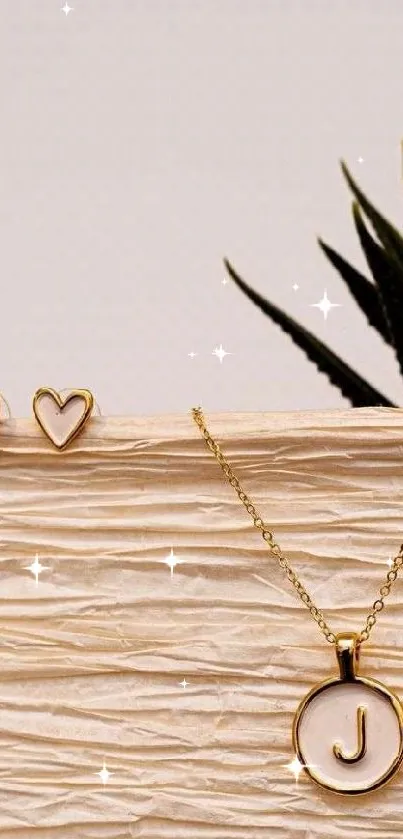 Elegant gold pendant and heart earrings on a beige paper background.