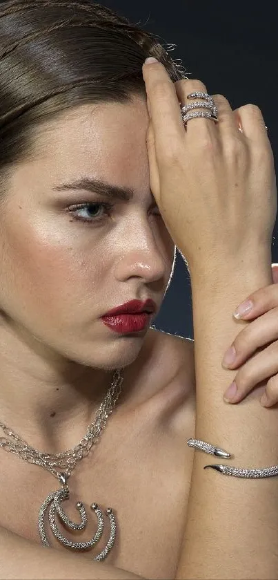 Model with jewelry against dark background.