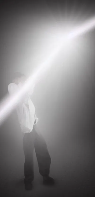 Man under bright light beam on dark backdrop.