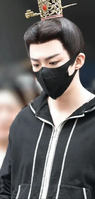 Man with decorative hairpiece and mask in stylish black attire.