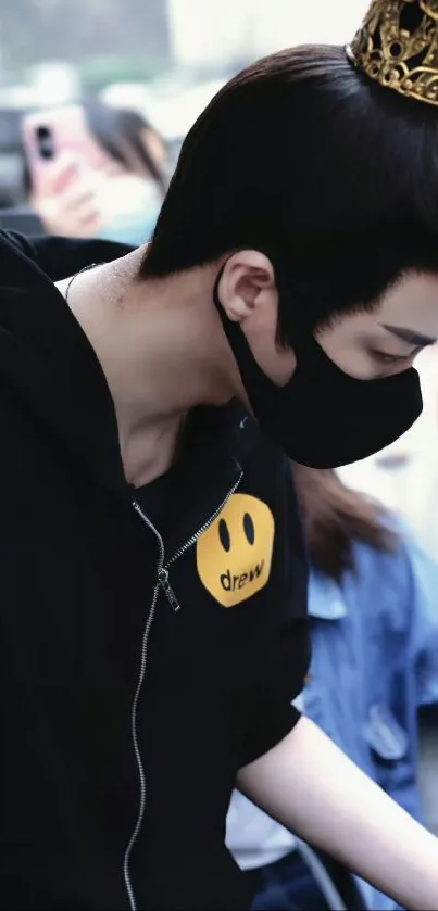 Person in black hoodie with a golden crown, exuding a stylish and royal vibe.