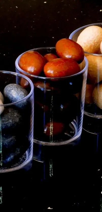 Minimalist stones in glass cups on black background