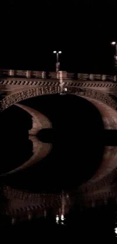 Elegant historic bridge over calm waters at night.