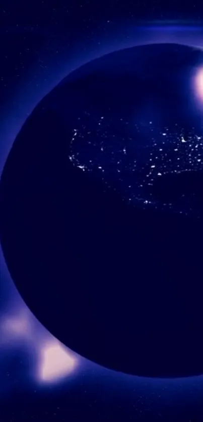 Night view of Earth with illuminated continents on a dark blue background.