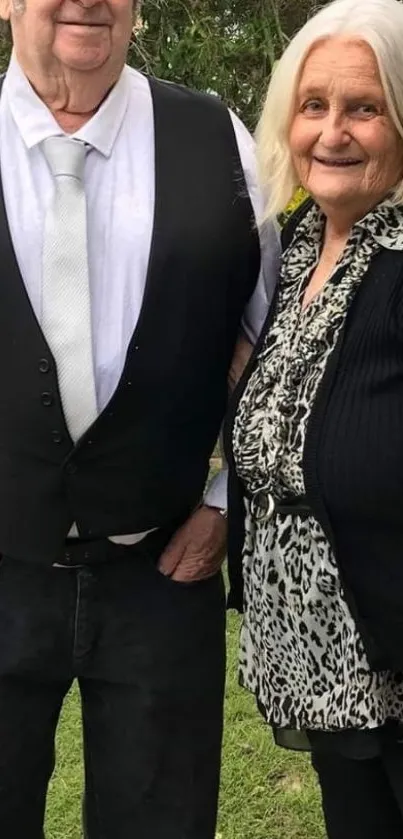 Senior couple in formal attire outdoors.