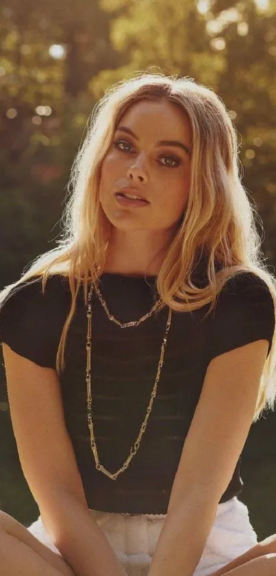 Blonde woman in black shirt sitting outdoors.