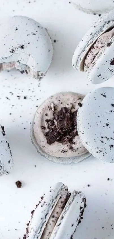 Light gray macarons with Oreo crumbles in stylish wallpaper.