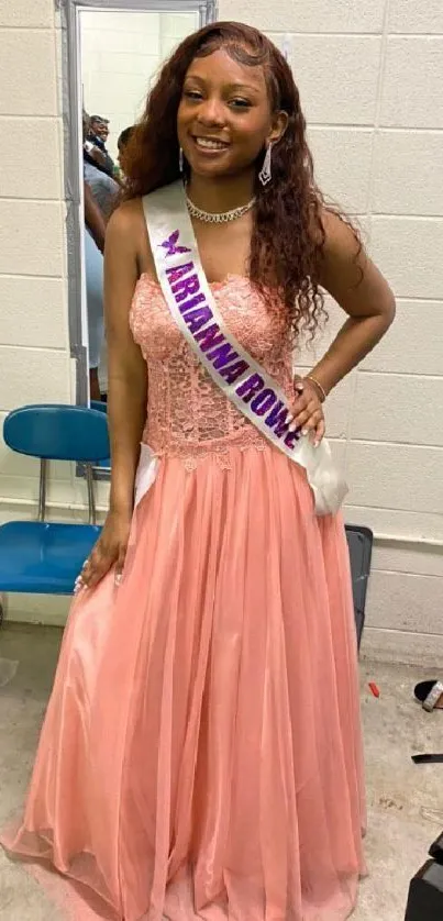 Young woman in a beautiful peach gown standing gracefully.