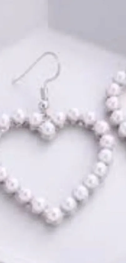 Elegant heart-shaped pearl earrings in soft white tones.