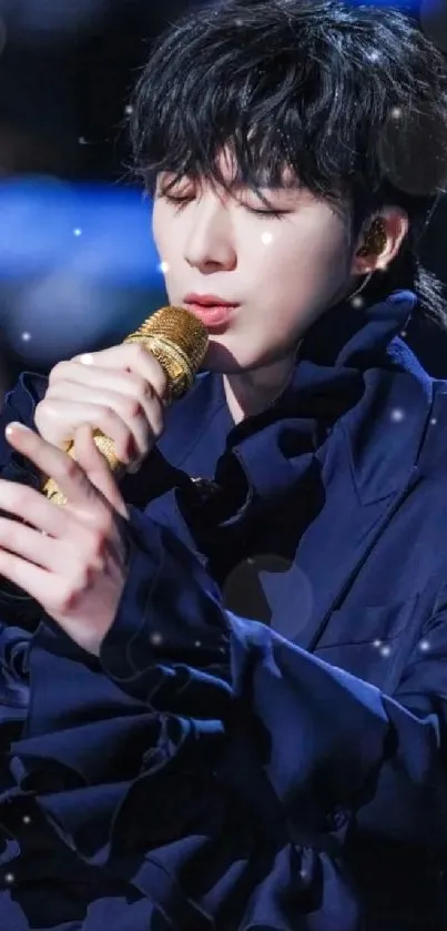 Performer in navy outfit with golden mic on stage.