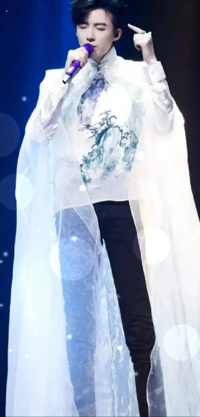 Performer in sheer white cloak on stage.