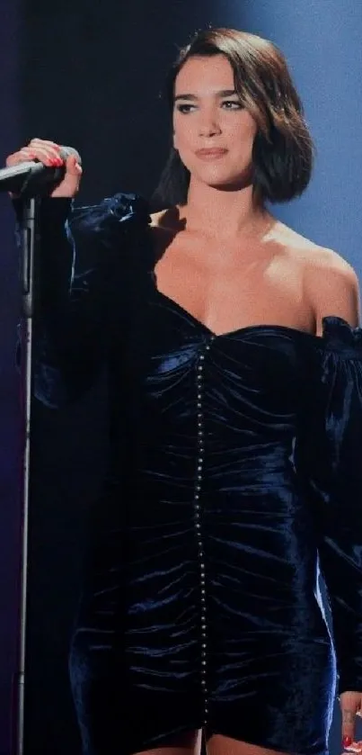 Woman in velvet dress singing on stage in spotlight.