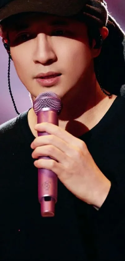 Performer with pink microphone on stage, soft pink ambiance.