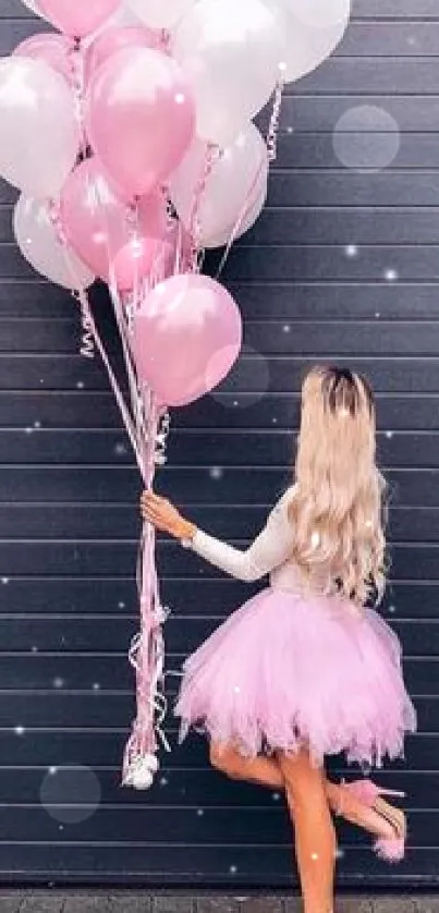 Woman with pink balloons against dark wall background.