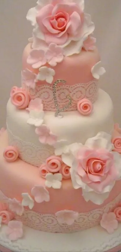 Three-tier pink cake with floral decorations.