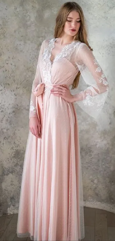 Woman in long pink gown against a textured wall.