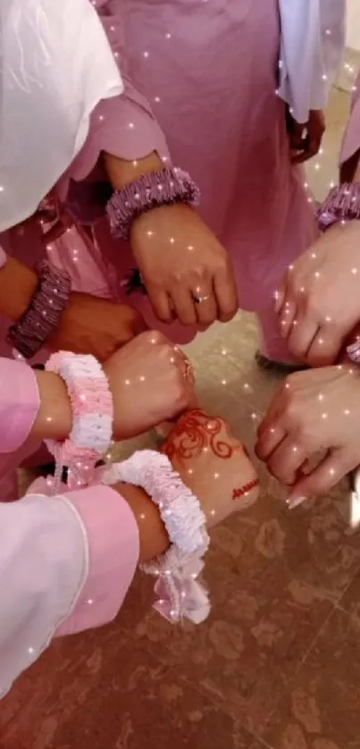 Hands with elegant pink bracelets forming a circle.