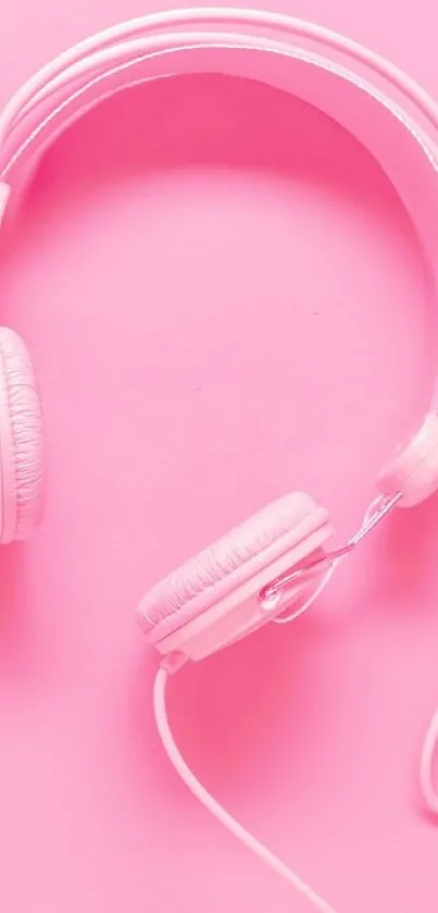 Pink headphones on a pastel pink background.