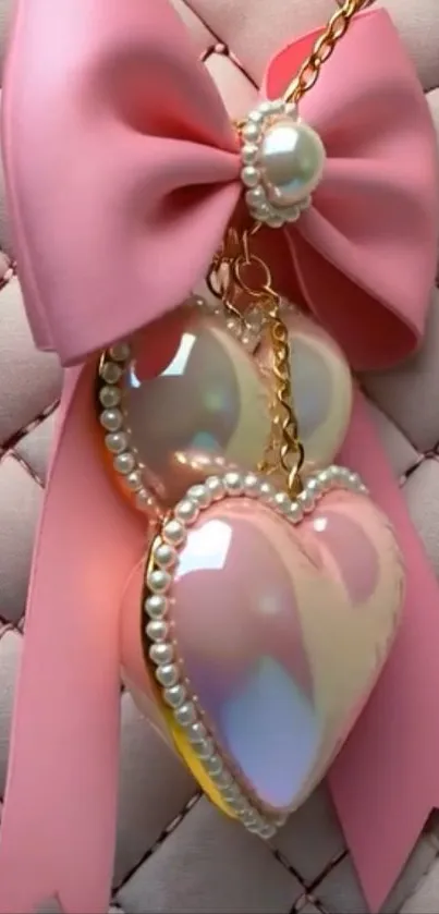 Pink heart charm with pearl bow on quilted background.